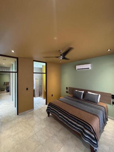 a bedroom with a bed and a ceiling fan at Casa Colibrí in Zipolite