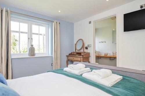 a bedroom with a bed with towels on it at The Cowshed in Truro
