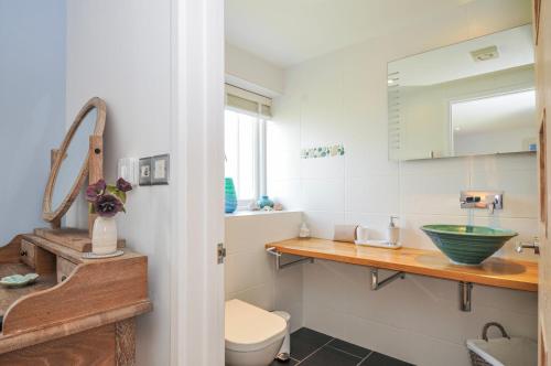 a bathroom with a sink and a toilet at The Cowshed in Truro