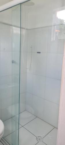 a shower with a glass door in a bathroom at Chácara Recanto do Sossego in Araçoiaba da Serra