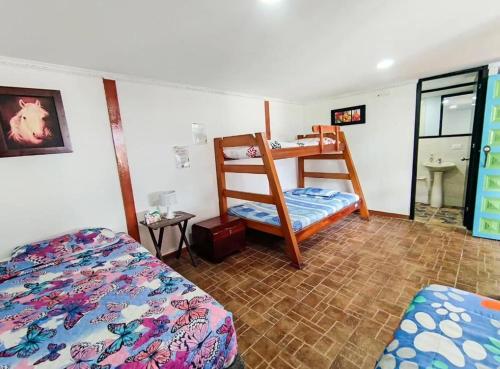 a bedroom with two beds and a bunk bed at Hostal Vistaguila in Salento