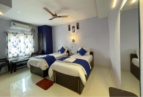 a bedroom with two beds and a ceiling fan at Hotel Sri Ram in Similigurha
