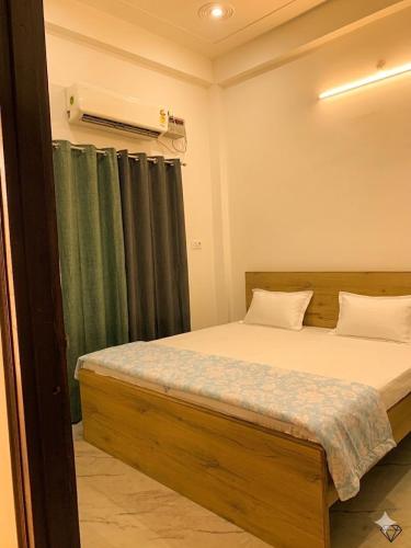 a bedroom with a bed and a green curtain at Baloon Rooms Taramandal in Gorakhpur