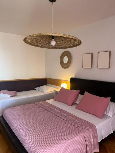 two beds in a room with a ceiling at Guest House Mijo Sokol in Brela