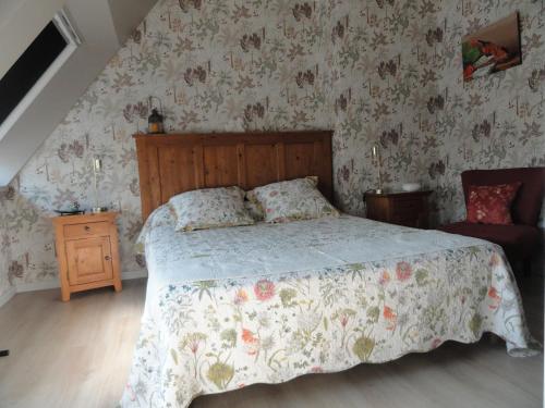 a bedroom with a bed with a floral wallpaper at CHAMBRES D'HÔTES LASSAY'rénité in Lassay
