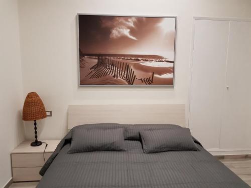 a bedroom with a bed and a picture on the wall at Casa vacanza Furlani in Grottaferrata