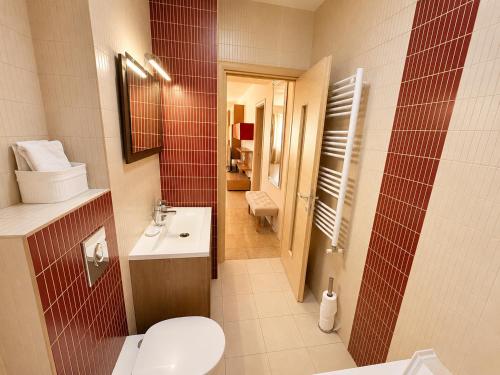 a small bathroom with a toilet and a sink at HERASTRAU APARTMENTS 3 camere self check-in in Bucharest