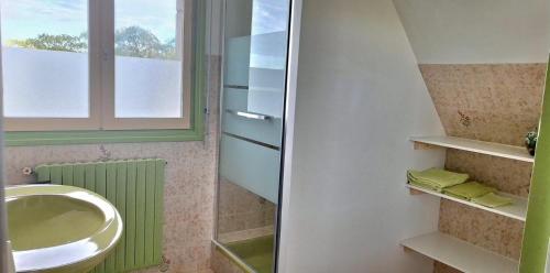 a bathroom with a sink and a toilet and a window at Bolumet in Neulliac