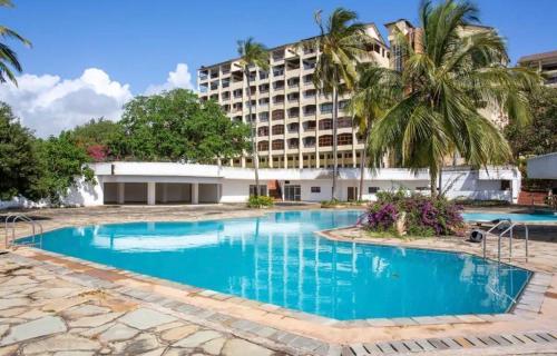 an empty swimming pool in front of a hotel at Beachfront Studio in Diani Beach