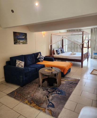 a living room with a couch and a bed at Beachfront Studio in Diani Beach