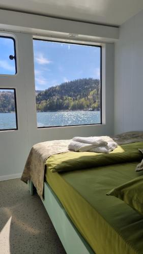 a bedroom with a bed and a large window at Baraj Izvorul Muntelui Bibanu in Bicaz