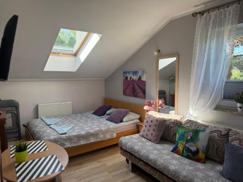 ein Schlafzimmer mit zwei Betten und einer Couch in der Unterkunft Kanarek in Ustka