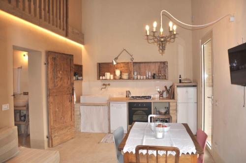 a kitchen with a table and a sink and a refrigerator at Borgo Farneto in Montecarotto