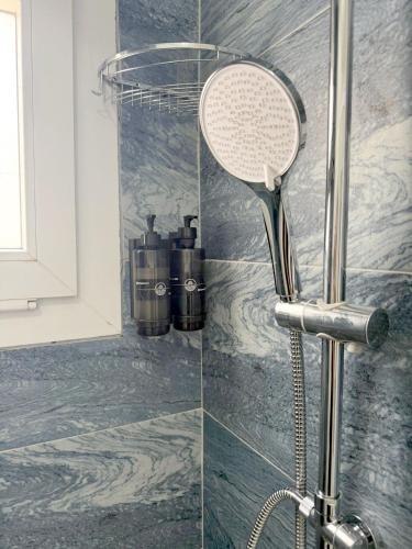 a shower with a shower head in a bathroom at Suda Pansiyon in Bodrum City