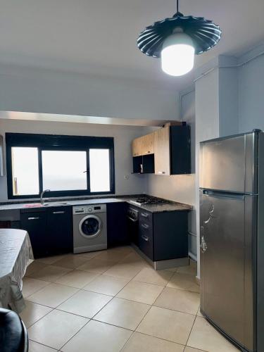 a kitchen with a stainless steel refrigerator and a dishwasher at Harmony immo in Bir el Djir
