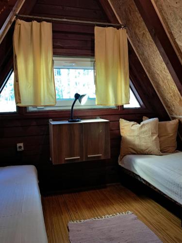a small room with a bed and a window at Domki Wakacyjne nad Jeziorem in Janowice