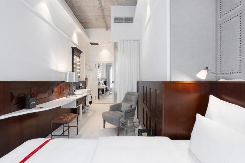 a hotel room with a bed and a desk and chairs at Ruby Lilou Hotel Marseille by IHG in Marseille
