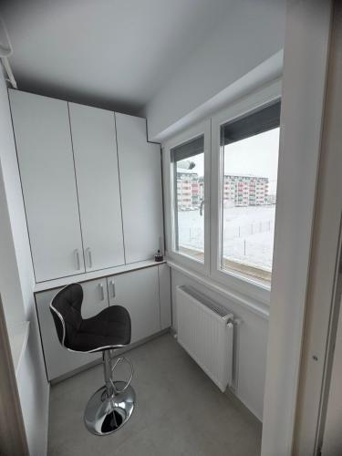 a black chair in a room with a window at Studio Militari Residence - MR1 in Chiajna