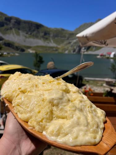 a person holding a plate of mashed potatoes at Rural Household MINIĆ - Kapetanovo jezero in Kolašin