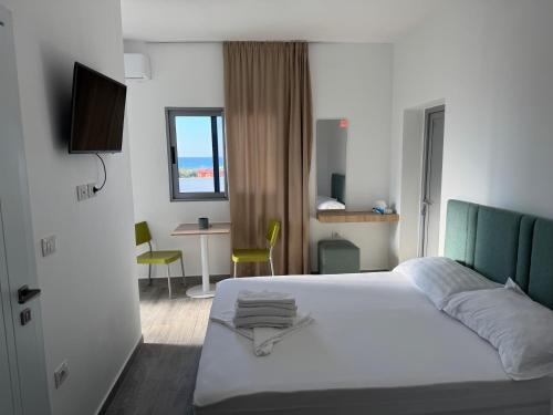 a bedroom with a white bed and a table and chairs at River Residence in Orikum