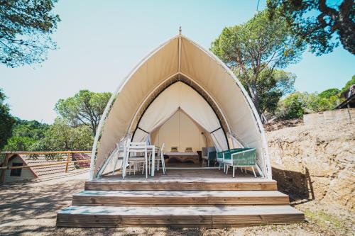 a tent with chairs and a table in it at Camping Turismar in Tossa de Mar