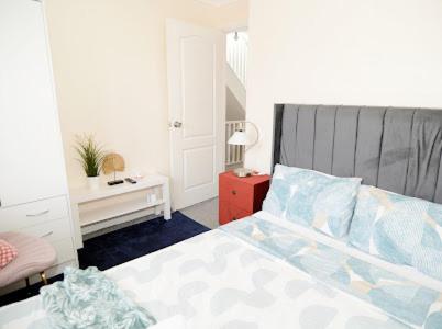 a bedroom with a bed and a table with a lamp at Luxurious & Spacious 5 Bedroom Property in Belvedere