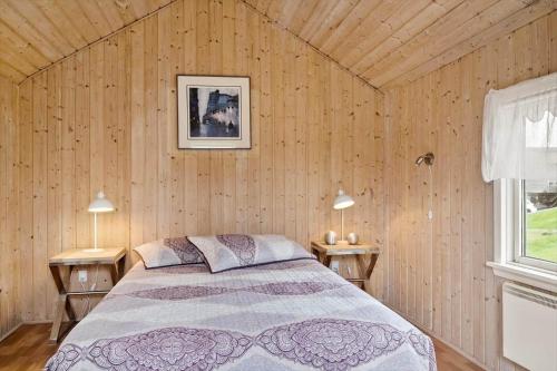 a bedroom with a bed in a wooden wall at G308-Lemvig-Violvej-108 in Lemvig