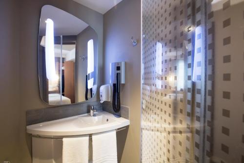een badkamer met een wastafel en een spiegel bij ibis Yerevan Center in Jerevan