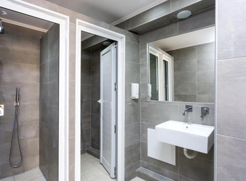 a bathroom with a sink and a shower and a mirror at Rethymno Youth Hostel in Rethymno