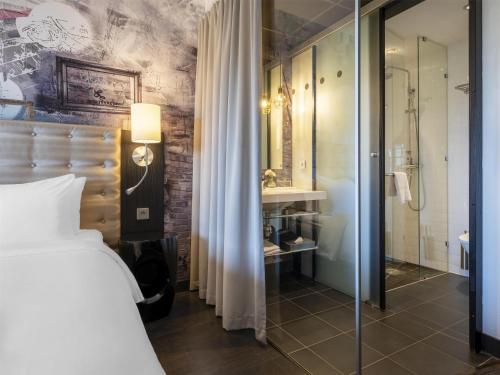 a bedroom with a bed and a bathroom with a shower at Radisson Blu Riverside Hotel in Gothenburg