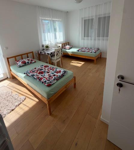 a room with two beds and a table in it at Ruhige Gästehaus AVOLli in Mellach
