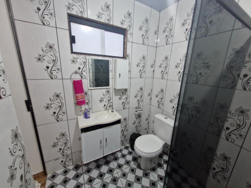 a bathroom with a toilet and a sink and a mirror at Casa da Nair in Sao Jorge