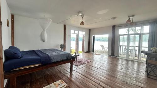 a bedroom with a bed on a hard wood floor at บ้านสวนริมอ่าง in Phayao
