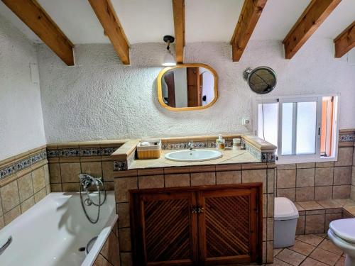 ein Badezimmer mit Badewanne, Waschbecken und Spiegel in der Unterkunft Can Lluna in Tárbena