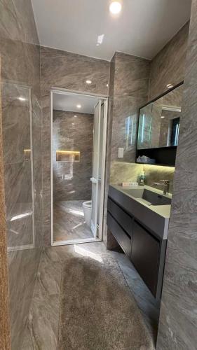 a bathroom with a shower and a sink and a mirror at Nâu Homestay in Hai Phong