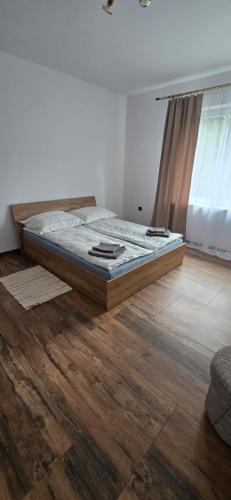 ein Schlafzimmer mit einem Bett und einem Holzboden in der Unterkunft Jarocin in Jarocin