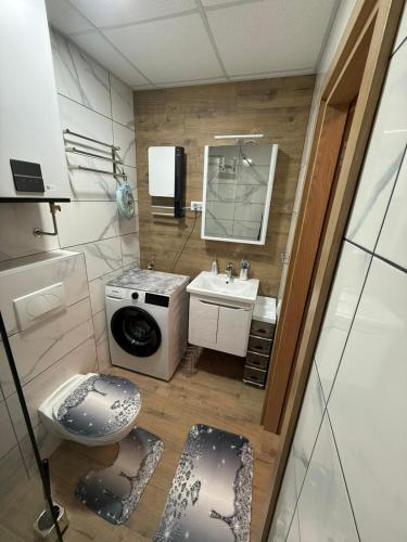 a small bathroom with a sink and a washing machine at Aurora Lux Wellness & Spa in Veliko Gradište