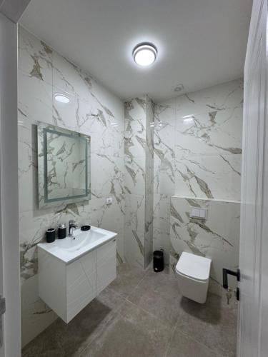 a white bathroom with a sink and a toilet at Morea Residence in Ulcinj