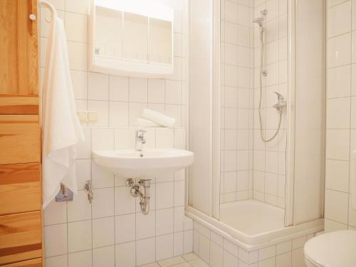 a white bathroom with a sink and a shower at Tschach in Kirchdorf
