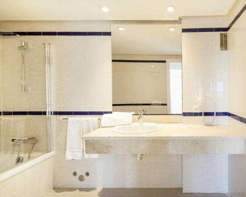 a bathroom with a sink and a shower at Ilunion Menorca in Cala Galdana