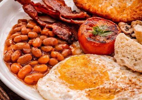 a plate of breakfast food with eggs bacon and beans at Island Lyfe Adventures Hotel - 5 Minutes from El Nido Airport & Lio Beach in El Nido