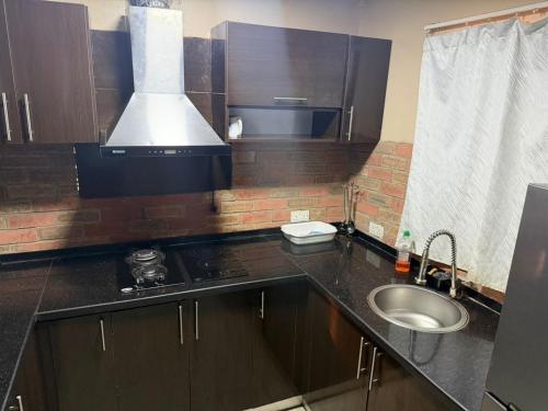 a small kitchen with a sink and a stove at NO 95 Suites LEKKI PHASE 1 in Ilado