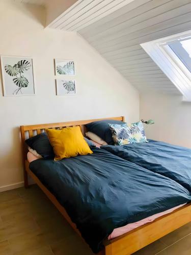 a bedroom with a bed with blue and yellow pillows at Ferien- Monteurwohnung in Zülpich in Zülpich