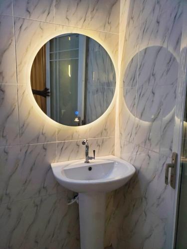 a bathroom with a sink and a mirror at Mega Luxury Apartment in Asagba