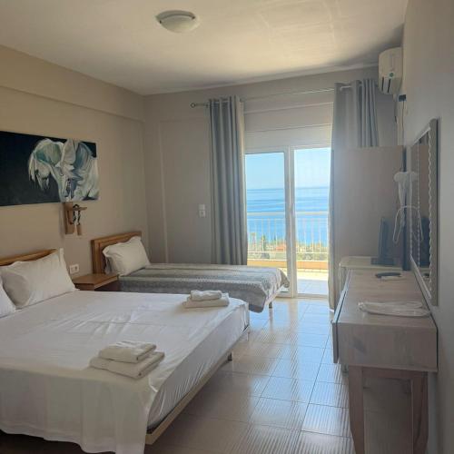 a hotel room with two beds and a view of the ocean at La Maroja View Hotel in Dhërmi