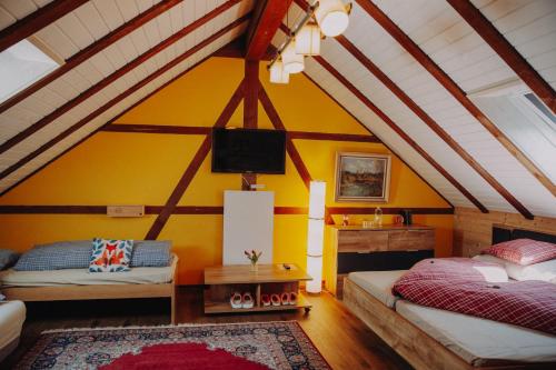 a room with two beds and a tv in a attic at Gasthaus Fuchsacker in Degersheim