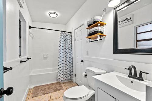 a white bathroom with a sink and a toilet at Surf Drive - Ultimate Beach Getaway for Families in Cocoa Beach
