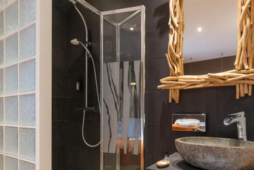 a bathroom with a shower and a sink at Hotel Aux Terrasses in Tournus