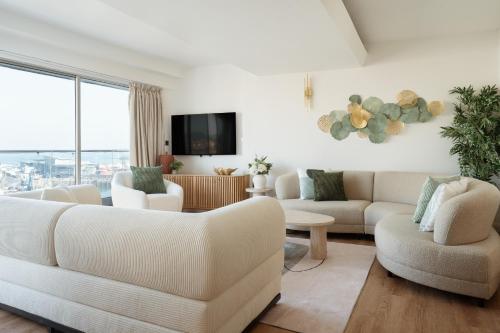 a living room with white furniture and a large window at Quayside Apartments, Brixham in Brixham