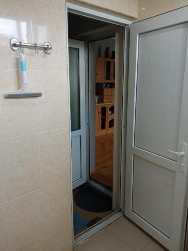 a bathroom with a sliding glass door with a mirror at Aisi in Stantsiya Sagaredzho